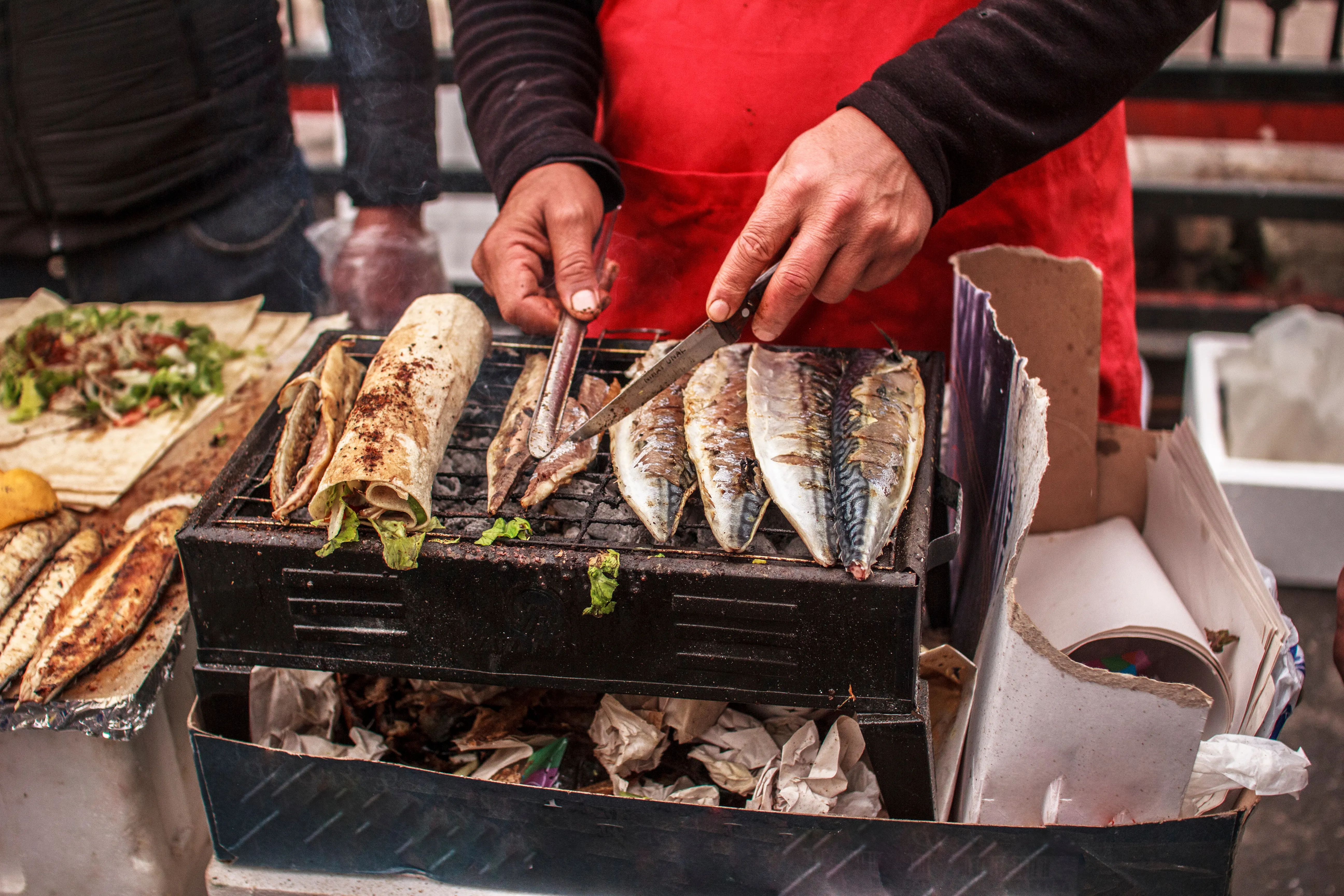 A grilled balık ekmek fish sandwich being prepared in Karaköy
