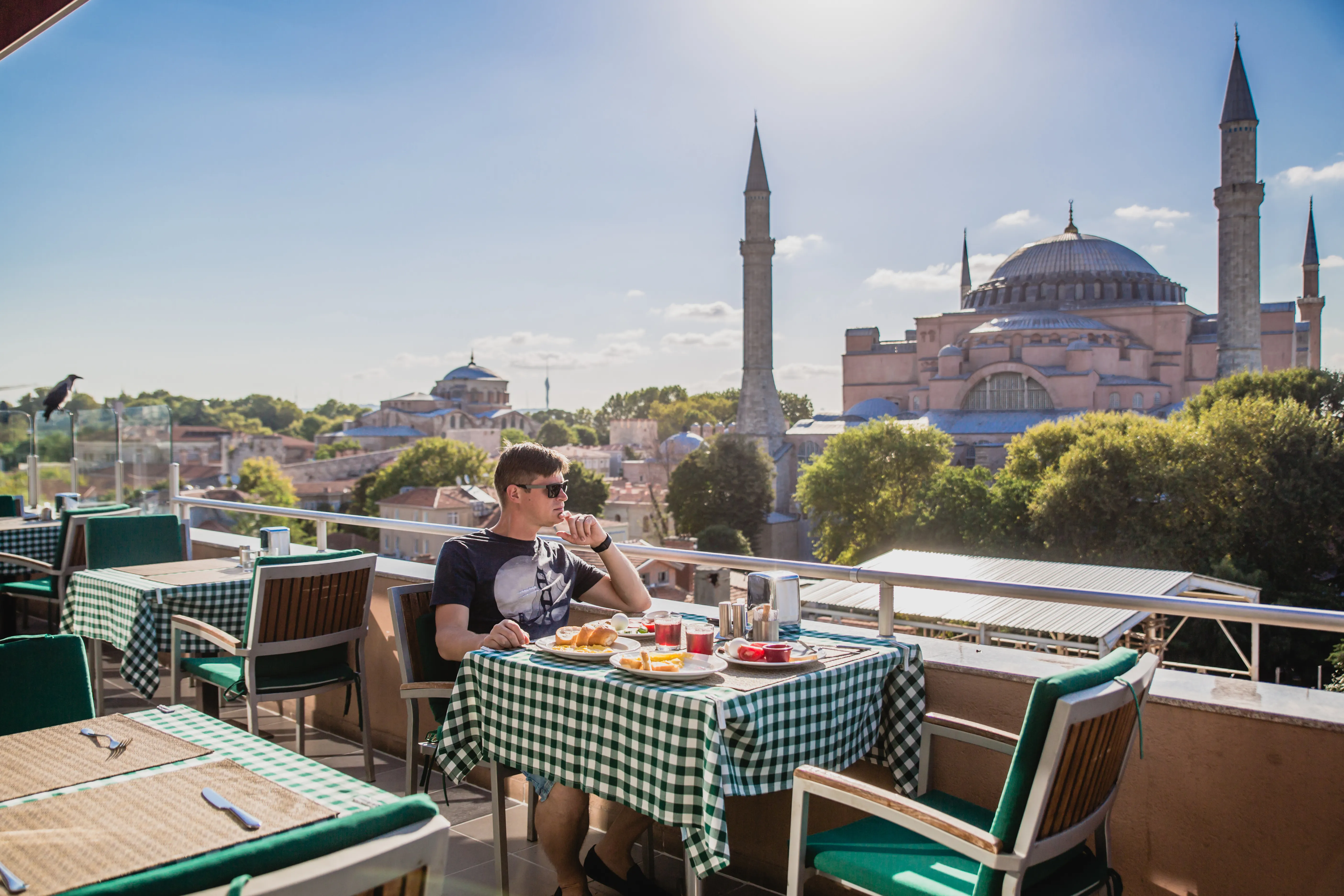 A sunny summer café terrace in Istanbul with people eating at outdoor tables