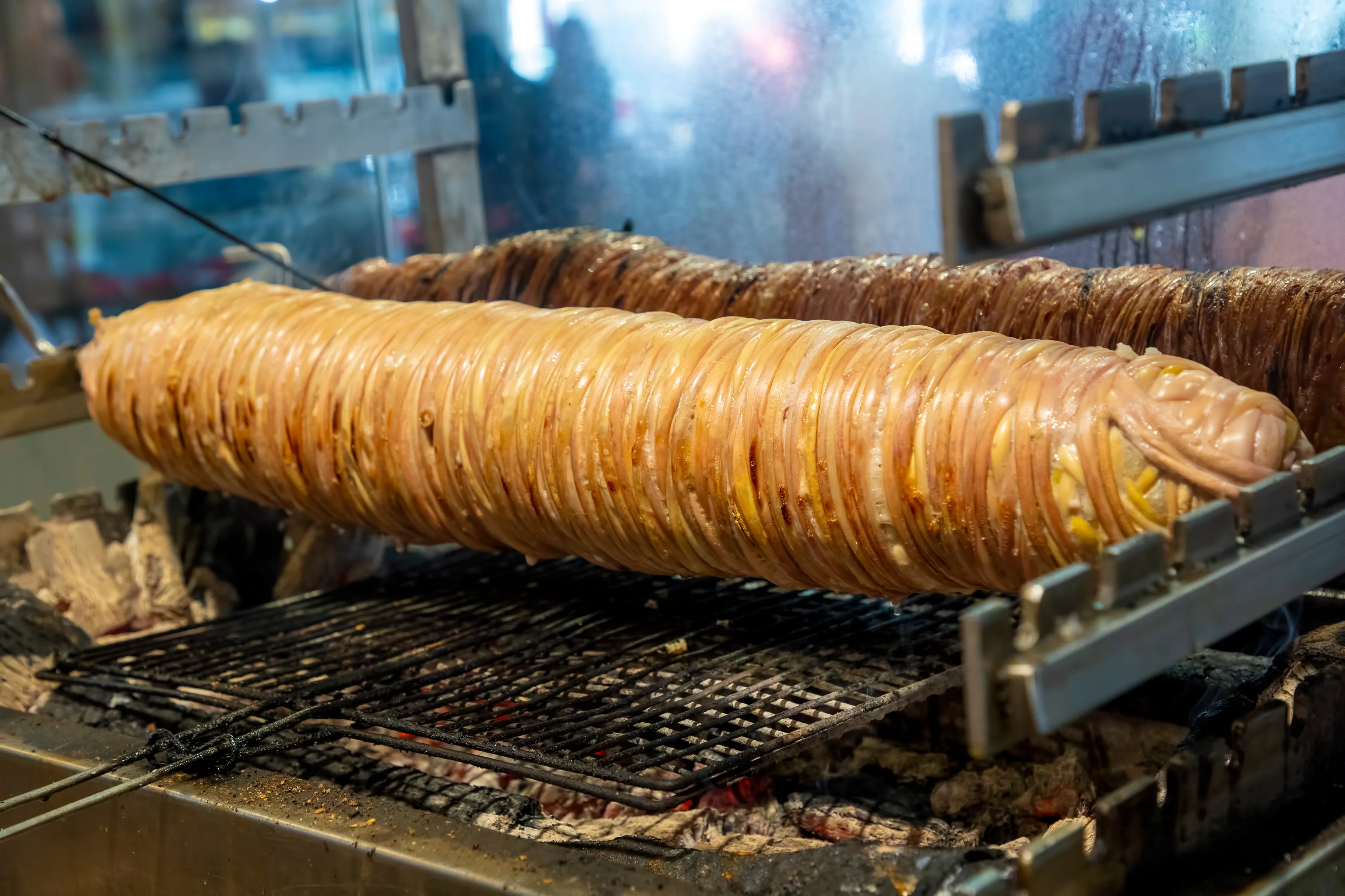 Kokoreç rolls roasting in a wood-fired Turkish street-food oven