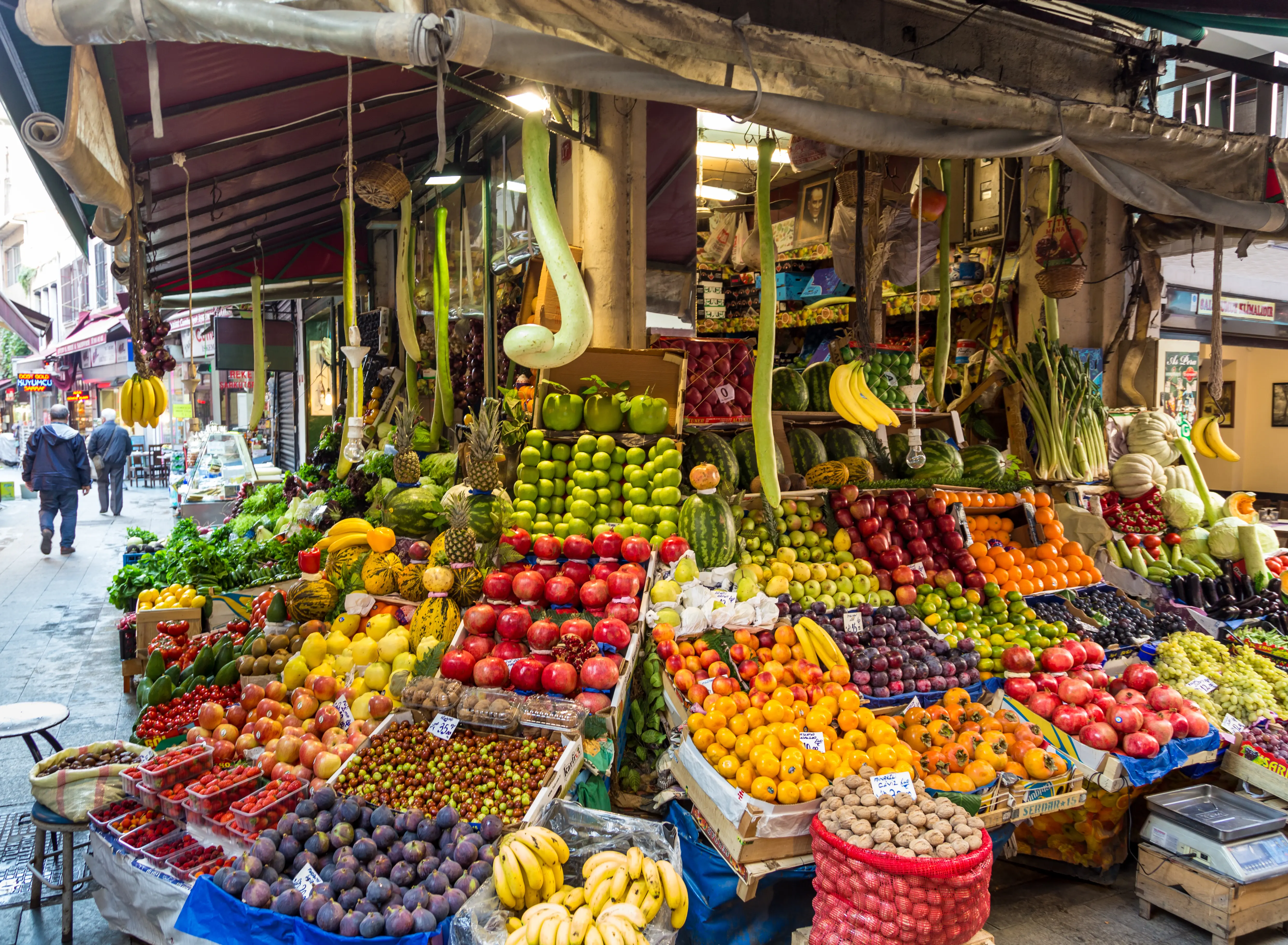 A traditional Turkish bazaar street lined with fresh fruit and vegetable stalls