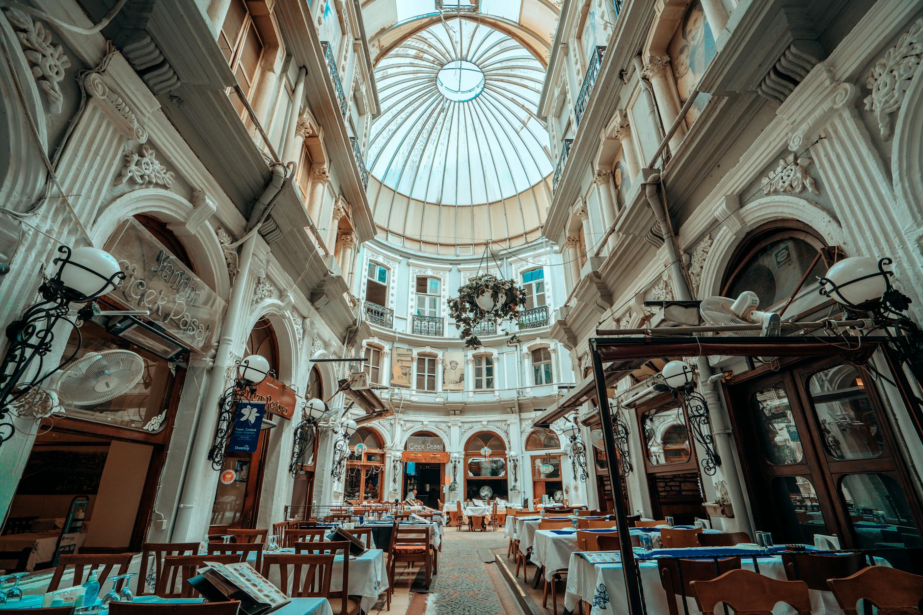 The domed glass-roofed interior of Çiçek Pasajı, a 19th-century Beyoğlu arcade lined with meyhane tables