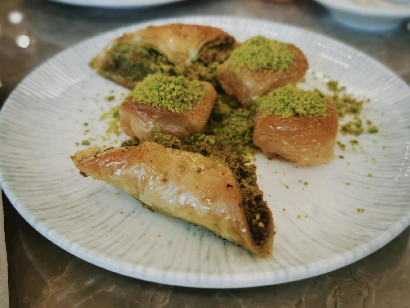 Close-up of freshly cut pistachio baklava with a heavy dusting of ground Antep pistachio
