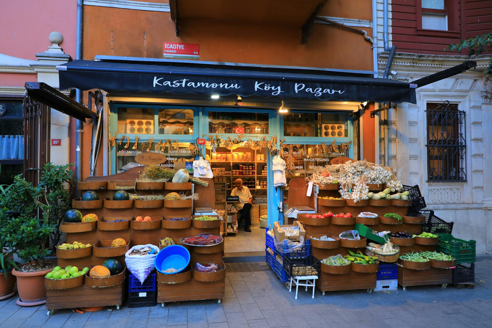 A small Kadıköy produce shop with wooden baskets of vegetables stacked along the pavement outside