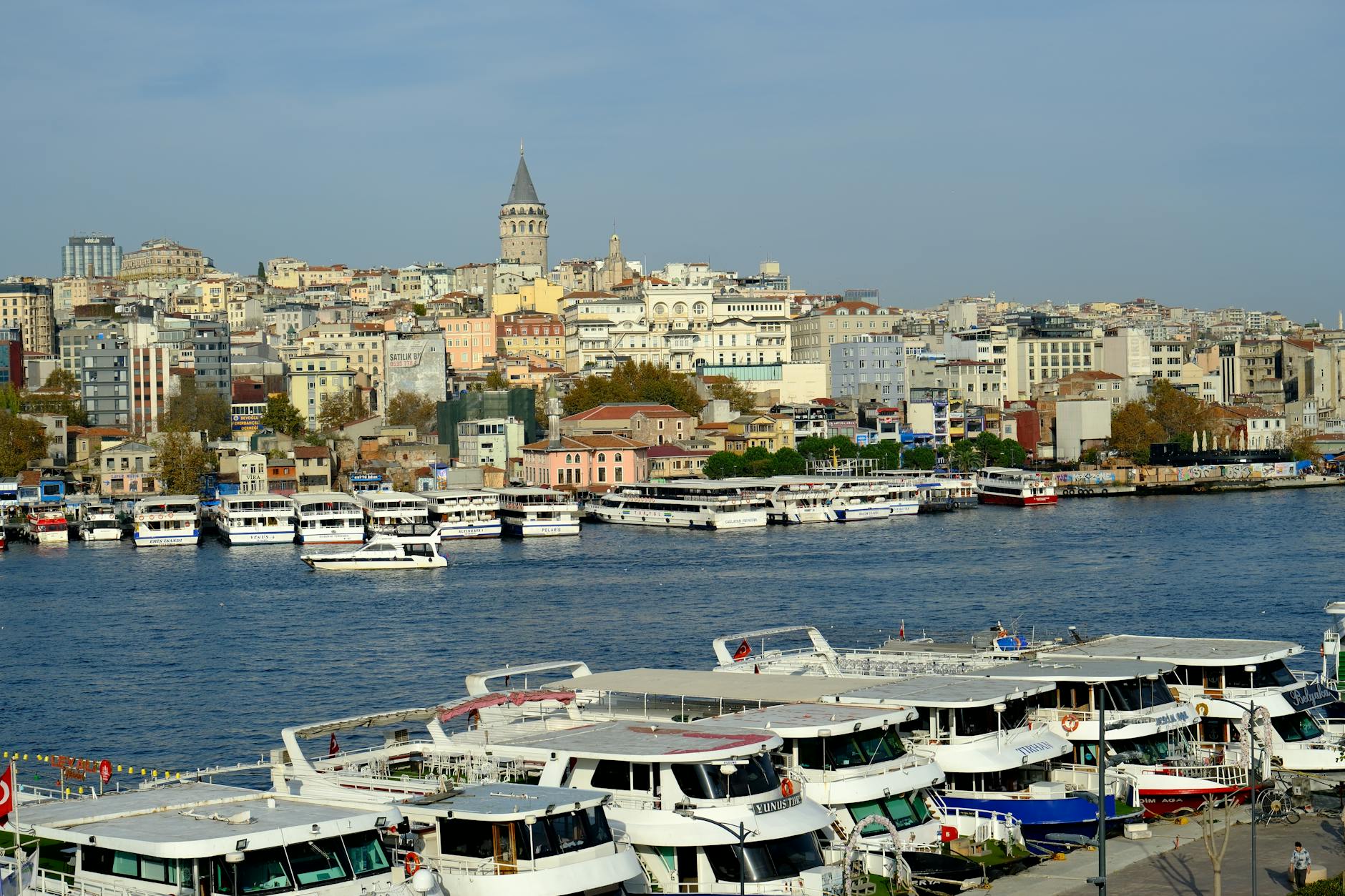 Karaköy waterfront with ferry boats moored at the pier and the Galata Tower rising behind