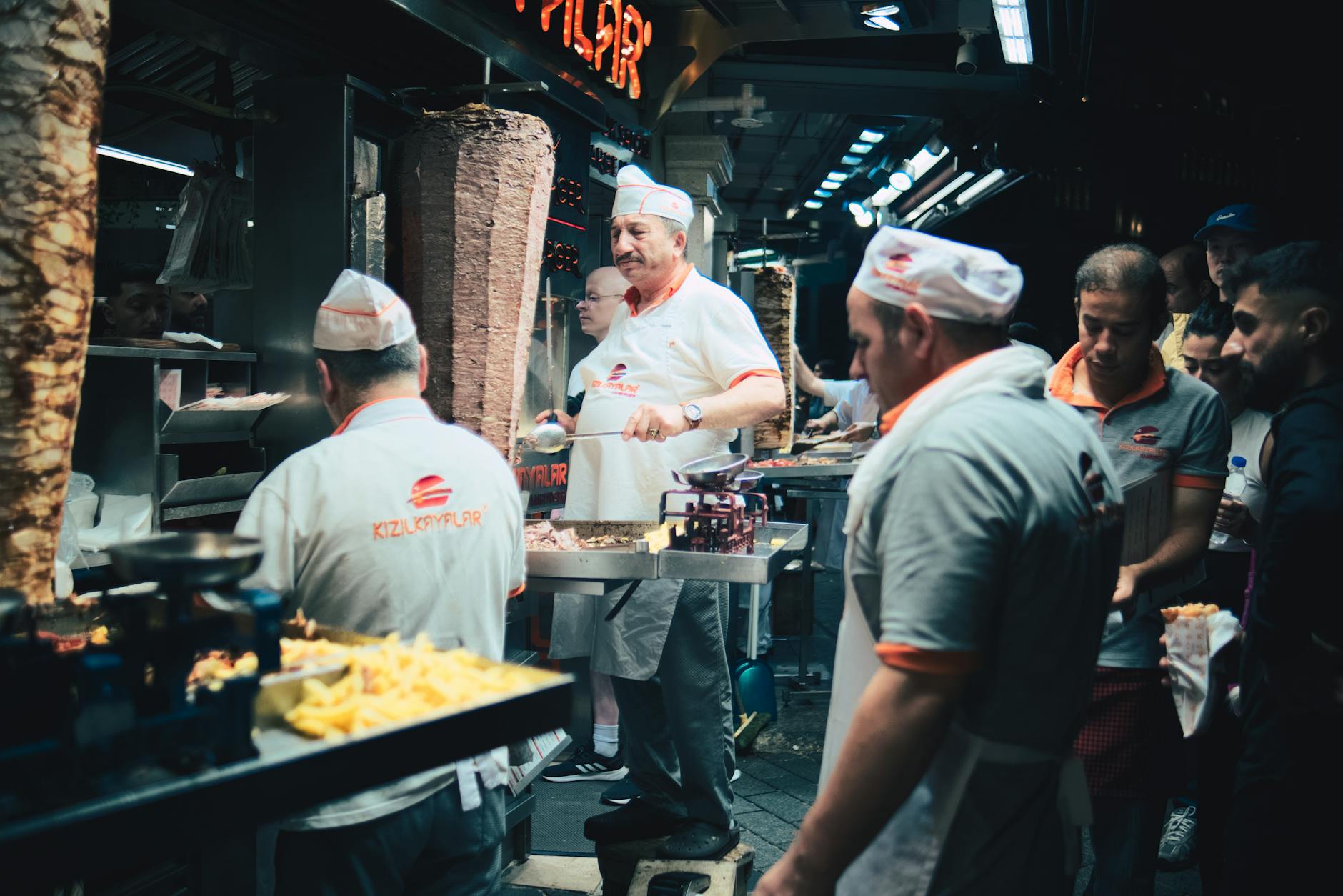 Late-night crowd and cooks with rotating döner spits at Kızılkayalar on Taksim Square, Istanbul