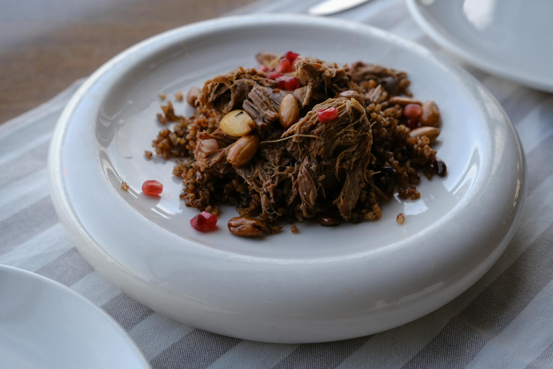A plate of slow-cooked shredded lamb with bulgur, pine nuts and pomegranate seeds, a classic Ottoman palace dish